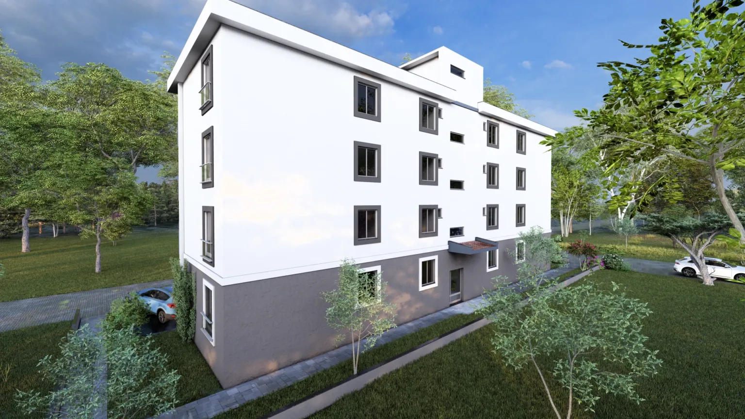 Rear corner perspective of a modern apartment building with a predominantly white façade, gray ground floor, multiple windows, and landscaped surroundings.