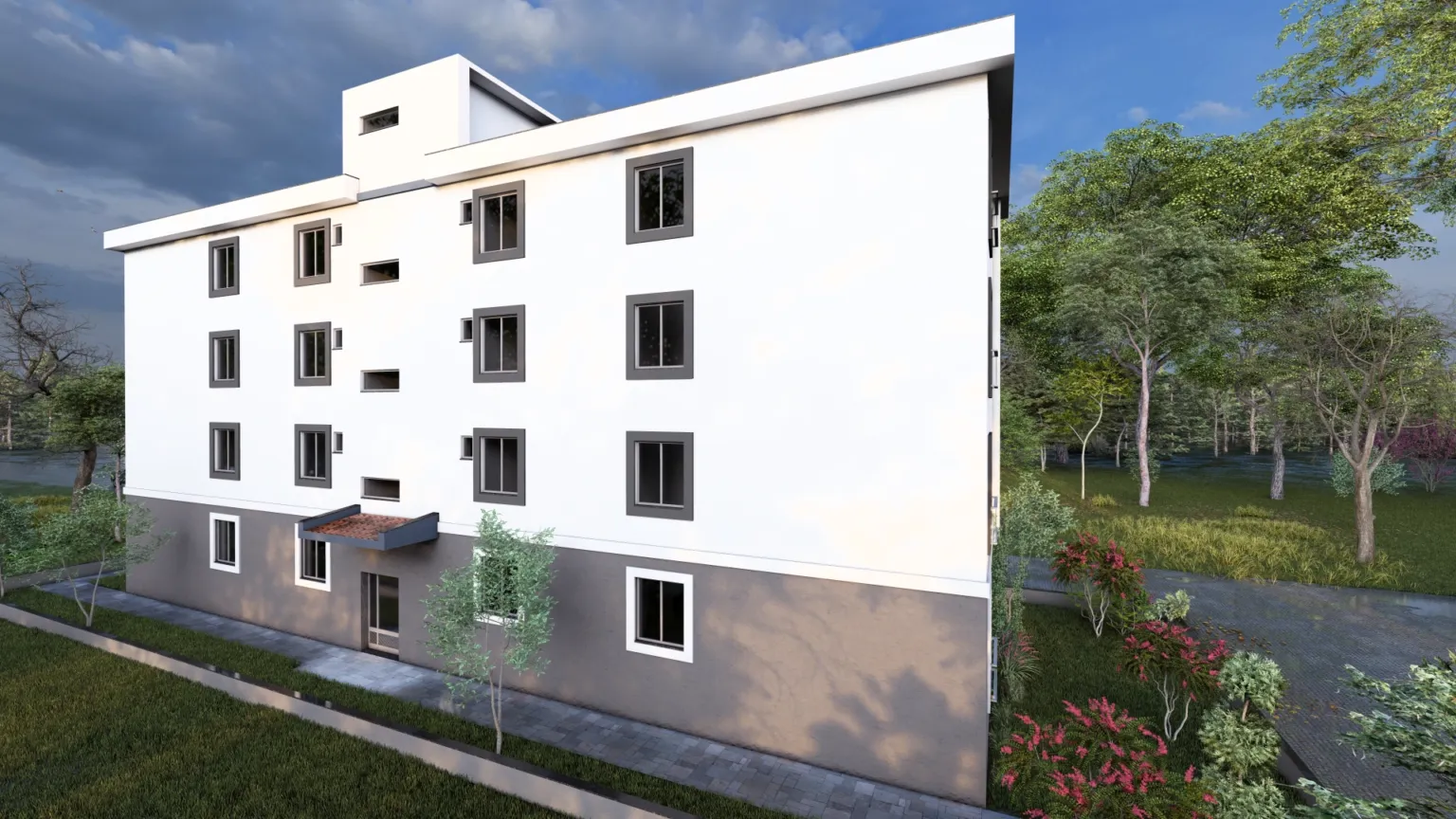 Angled rear view of a modern apartment building with a white façade, gray lower level, framed windows, entrance canopy, and surrounding landscaping.