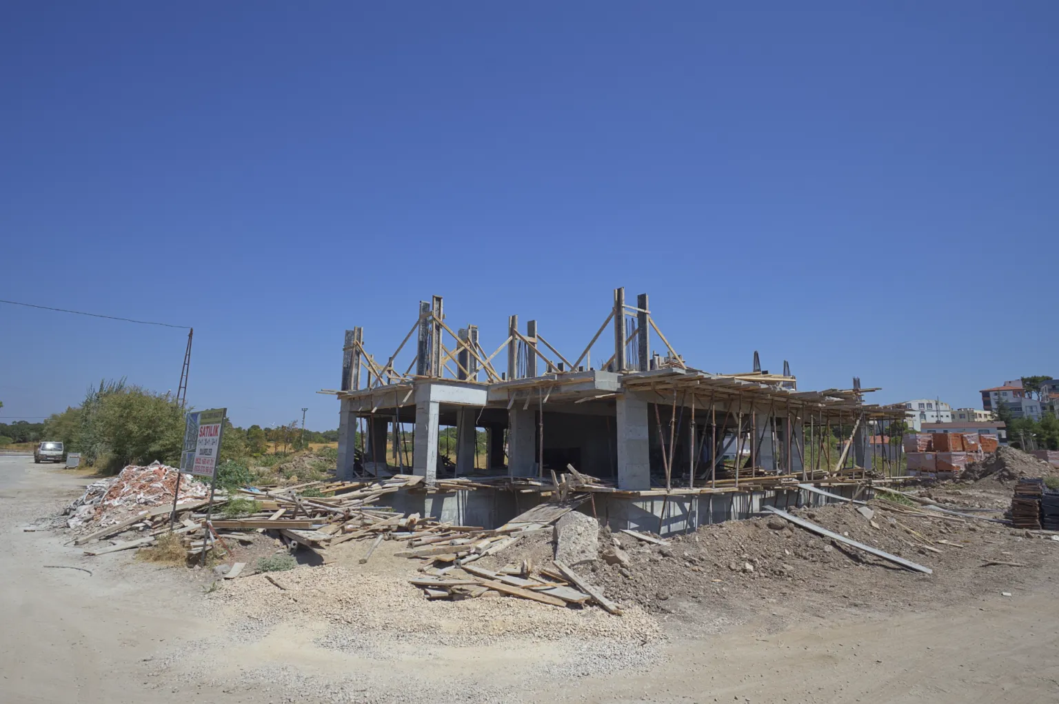 Kolon donatıları ve üst kat kalıpları hazırlanan betonarme yapının ön cephesinden şantiye görünümü.